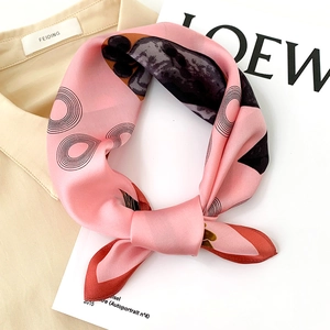 Detail eines rosa Seidenschals mit geometrischen Ringen und Blumendruck auf Hemd