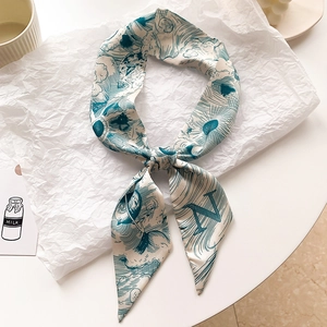 Détail d'un foulard étroit en soie avec illustrations de planètes et imprimé lettre N