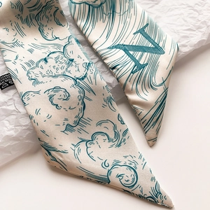 Gros plan du foulard en soie Twilly avec motifs de vagues et détails de la lettre N