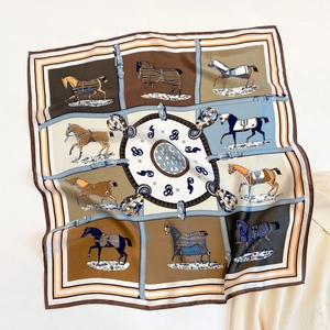 Dettaglio di motivi equestri e cavalli su un elegante foulard quadrato di seta