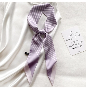 Detail shot of purple and white striped skinny silk scarf on white silk background