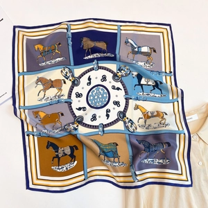 Dettaglio di un foulard in seta con stampa equestre classica e motivi di staffe dorate