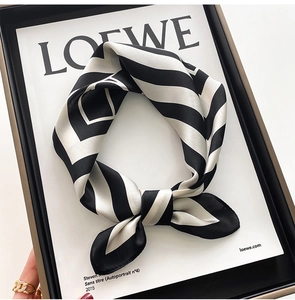 Close-up of black and white striped silk scarf with elegant knotting and glossy texture