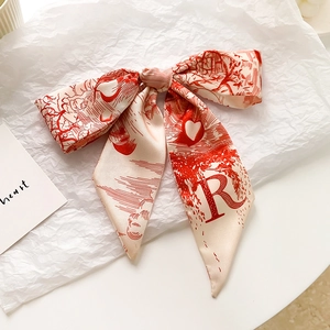 Détail d'un foulard en soie avec motif Toile de Jouy rouge et impression de lettre R