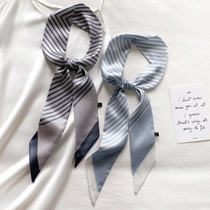 Detail showing striped long skinny scarves in grey and blue with silk texture