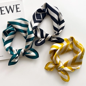 Detail view of striped silk neck scarves in green, black, and yellow colors