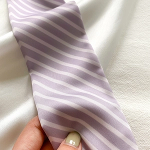 Close-up of lightweight purple and white striped silk scarf with soft texture and smooth sheen