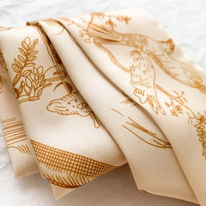 Détail d'un foulard en soie avec d'élégants motifs d'oiseaux et d'illustrations botaniques