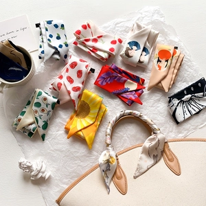Dettaglio di vari foulards in seta avvolti sui manici delle borse e decorazioni