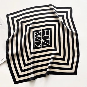 Detail of black and white striped silk square scarf with satin finish on white background