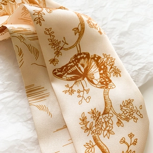 Vue détaillée du foulard en soie champagne avec imprimé floral vintage et papillons