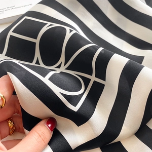 Close-up of a soft black and white striped silk scarf showing smooth texture and drape
