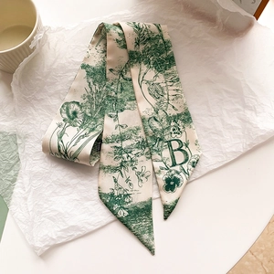 Détail d'un ruban en soie crème à motif floral vert et lettre décorative B pour sac