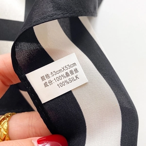 Detail of 53x53cm black and white striped silk scarf with 100% mulberry silk label