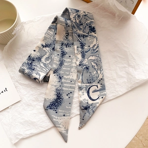 Détail d'un foulard en soie bleu Toile de Jouy avec la lettre C et des motifs d'étoiles