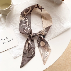 Gros plan d'un foulard en soie noué sur papier avec une tasse et une citation