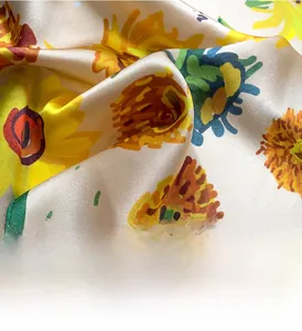 Détail macro d'un foulard carré en soie avec des motifs de tournesol imprimés en numérique