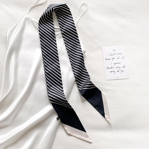 Detail shot of black and white diagonal striped skinny silk scarf with a contrast tip