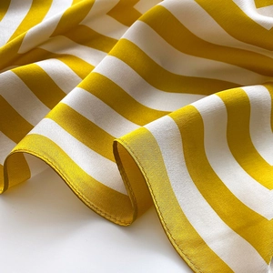 Detail of yellow and white striped silk scarf showing high-quality rolled hem edges