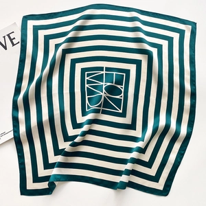 Close-up of high-quality silk scarf featuring green and beige geometric stripe patterns