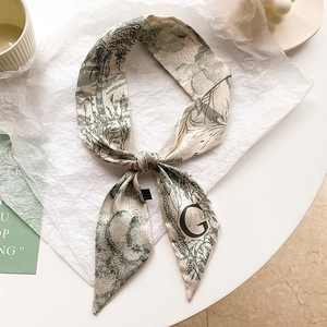 Vue détaillée du foulard étroit en soie crème avec imprimé floral vert et lettre G brodée