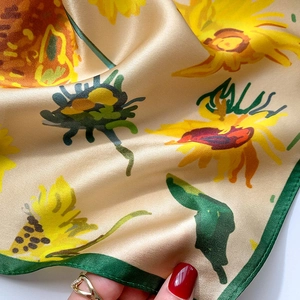 Détail du foulard en satin à imprimé tournesol montrant texture lisse et aspect brillant