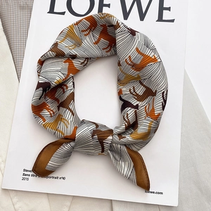 Elegant silk scarf with horse patterns and geometric lines on white fashion magazine
