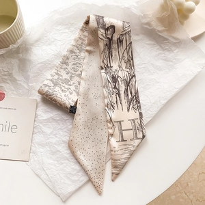 Détail d'un foulard twilly en soie avec vagues vintage et imprimé lettre H sur papier