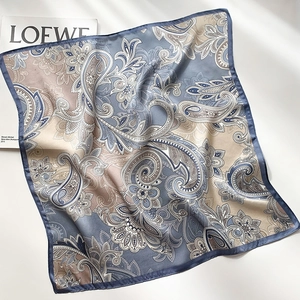 Détail du foulard en soie à motif paisley avec ourlet cousu et finition satinée chic