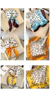 Detailed view of floral pattern scarves with small hat prints styled on a beige suit