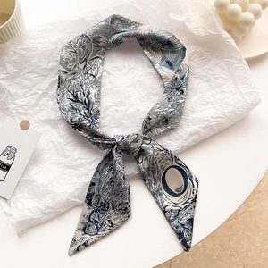 Détail d'un élégant foulard en soie aux motifs floraux vintage noué avec un style chic