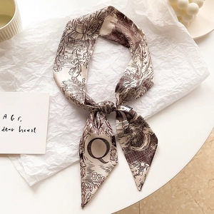 Gros plan détaillé d'un foulard en soie étroit avec imprimé rétro et lettre Q
