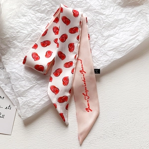 Dettaglio di un foulard sottile con stampa di pompelmo ed etichetta del marchio