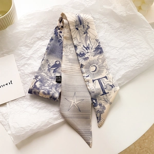 Détail d'un foulard étroit en soie avec imprimés lune et étoiles sur fond artistique