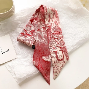 Détail macro d'un foulard en soie style Jouy avec motifs rouges et lettre U imprimée
