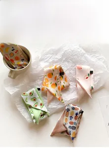 Detailed macro view of assorted silk-like fruit print skinny scarves and necktie headbands