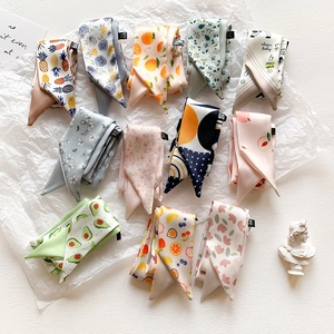 Flat lay of multiple silk-feel headbands with cute fruit and floral patterns on white texture