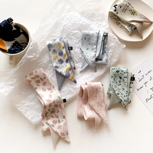 Flat lay of multiple tie-dye floral silk scarves on white paper for elegant styling