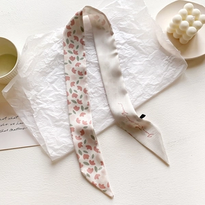 Detail of floral silk scarf with pink flowers and artistic lettering on folded paper