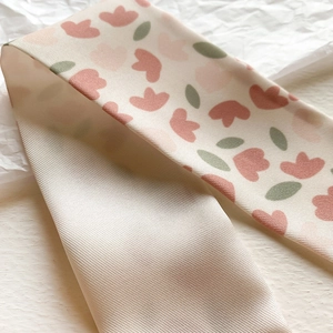 Detailed close-up of pink tulip print and champagne gold satin back on a twill silk scarf