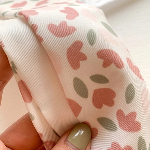 Close-up of pink tulip print on twill faux silk fabric showing detailed weave texture