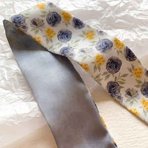 Detail of floral silk scarf showing blue yellow pattern and twill fabric texture
