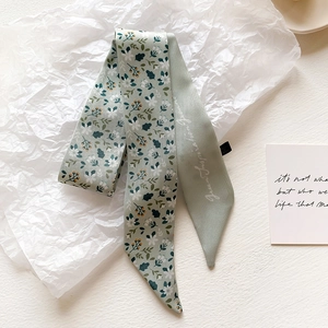 Detailed view of sage green floral tie-dye silk scarf on white textured paper
