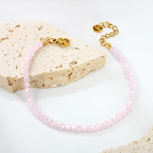 Bracelet en perles roses facettées avec fermoir en acier doré et étiquette S.Steel