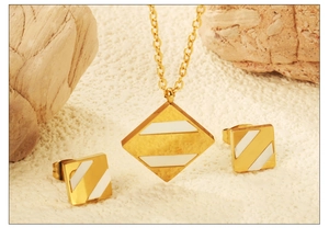 Vue détaillée d'une parure de bijoux géométriques dorés avec incrustation de coquillage