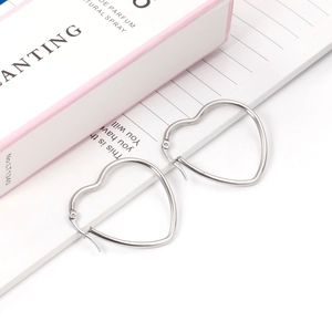 Detail view of heart-shaped silver stainless steel hoop earrings with clicker closure