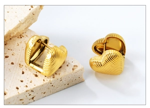 Detail of 18K gold plated heart earrings featuring a unique vertical pleated metal texture