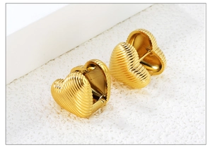 Detailed macro view of heart-shaped 18K gold plated earrings with vertical ribbed texture