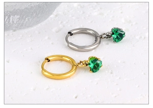 Gros plan détaillé des boucles d'oreilles créoles coeur en zircon vert et or 18k