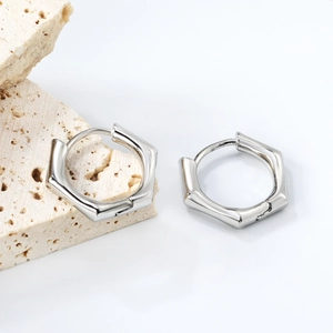 Boucles d'oreilles créoles hexagonales argentées avec finition géométrique en acier poli